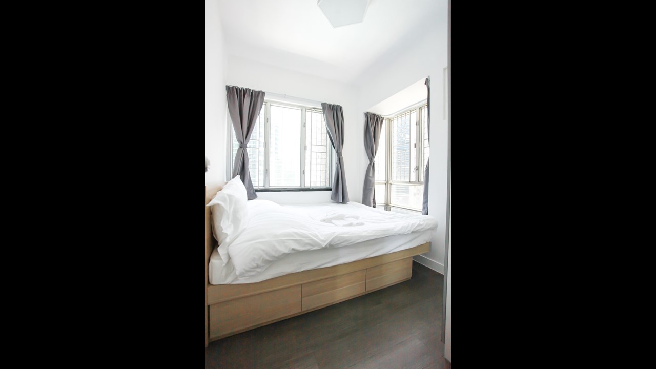 Queen size bed facing windows in Fortress Hill 2 BR serviced apartment Hong Kong
