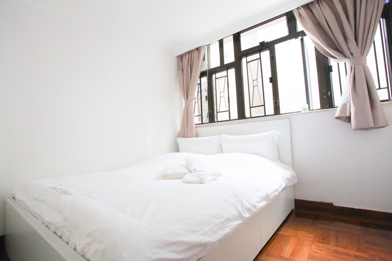 Queen size bed facing window in Fortress Hill 2 bedrooms Apartment