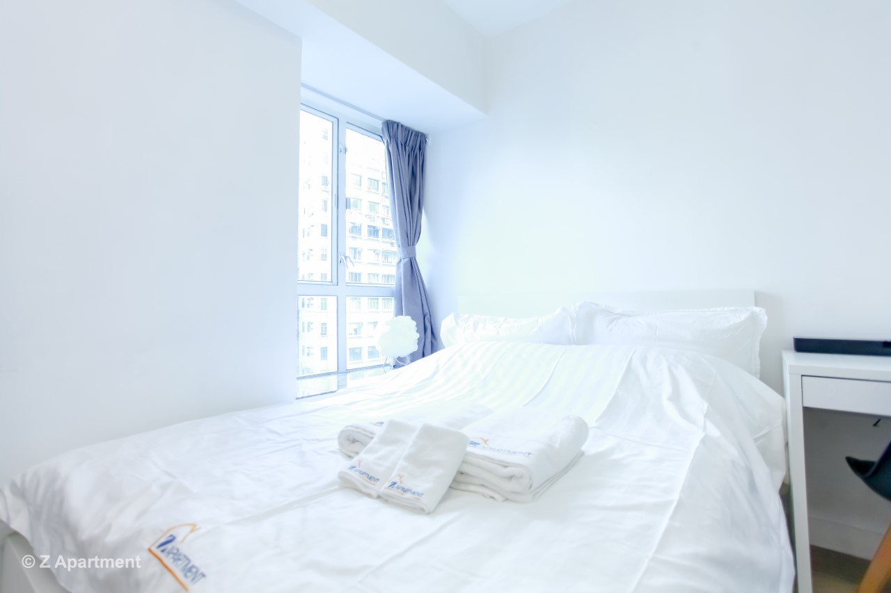 Double bed facing window in Tin Hau studio flat 